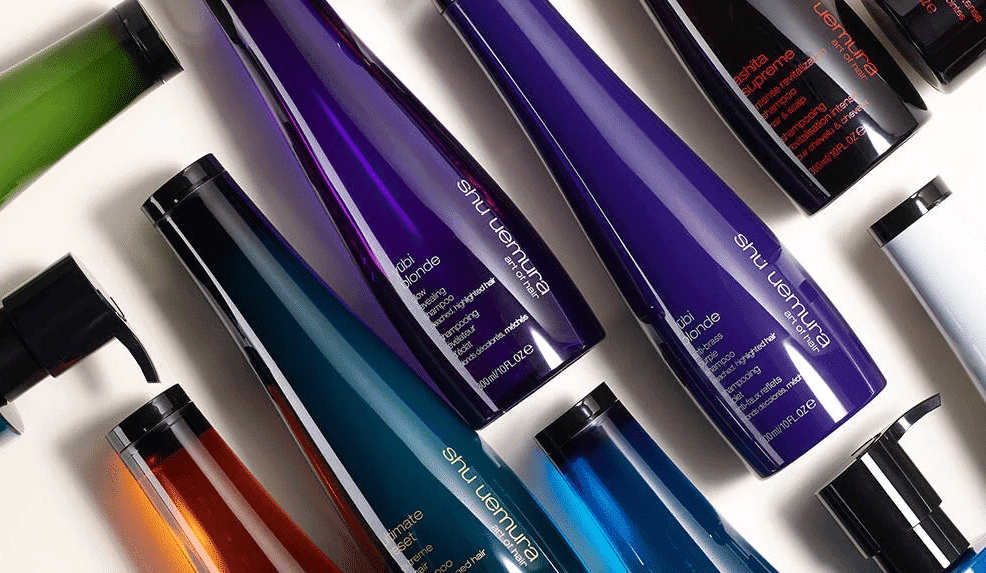 Colorful shampoo bottles arranged on a white background, viewed diagonally.