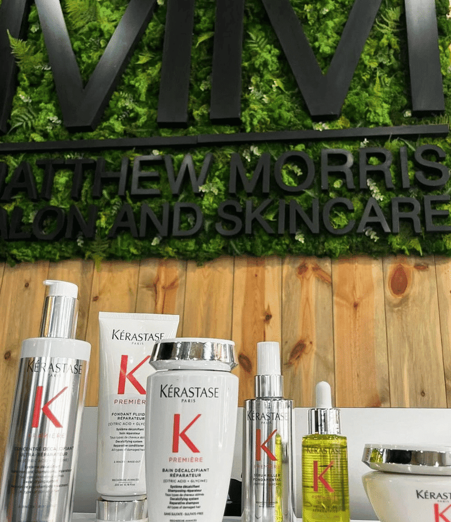 Kérastase products displayed at a hair salon and skincare center with green wall decor.